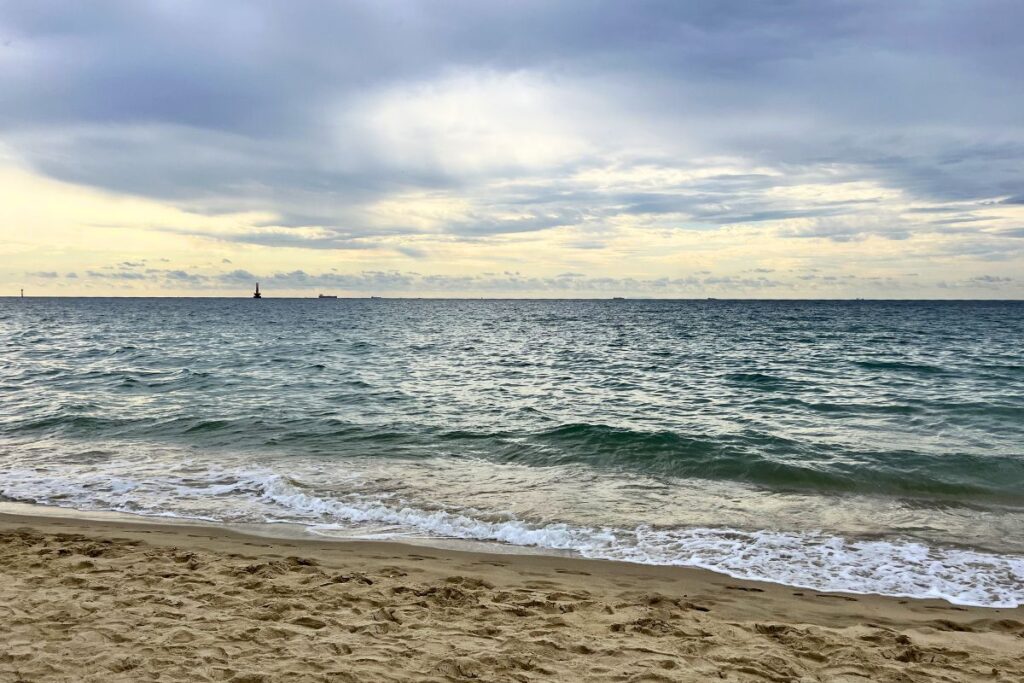 A shot of the ocean along the coast of Busan with a sandy beach.