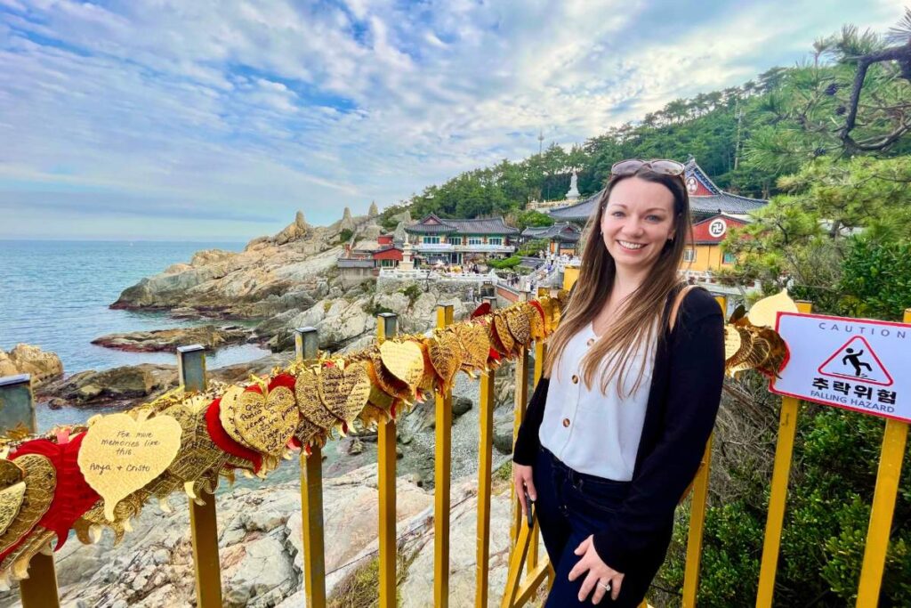 Krysti standing at a lookout point with Haedong Yonggungsa Temple in the background.