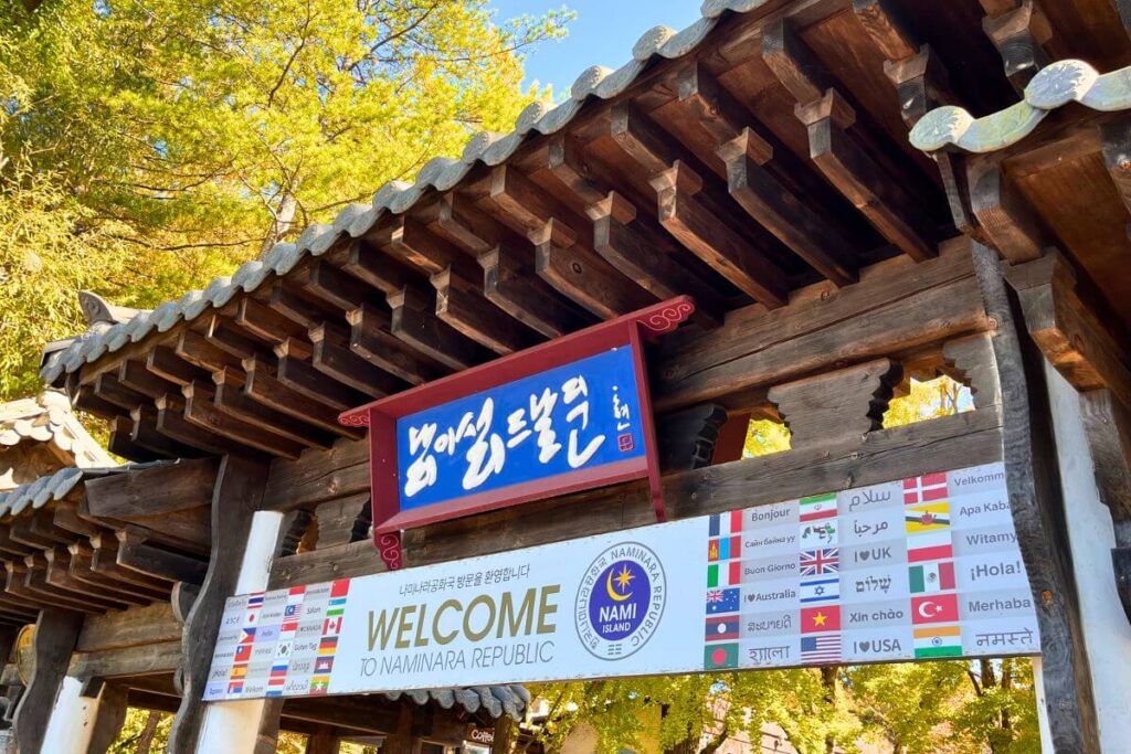 Large wooden gate at entrance to Nami Island that says "Welcome."
