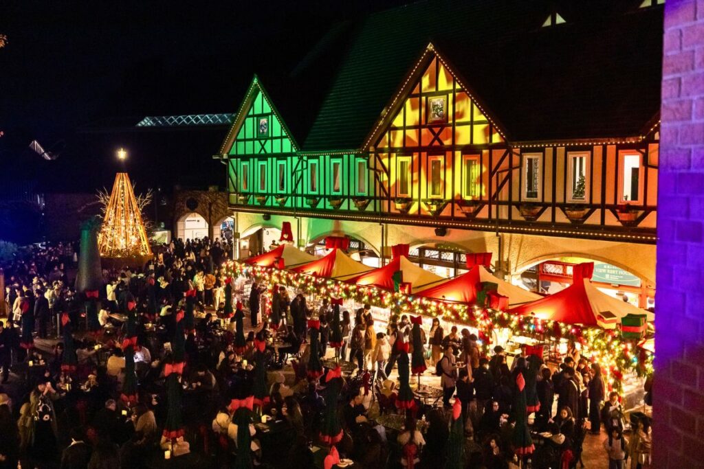 View overlooking Kobe Christmas Market with European-style building illuminated in holiday colors.