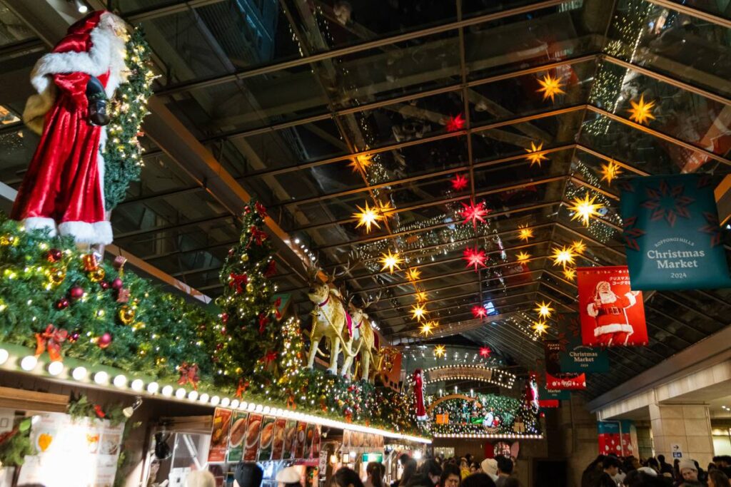 Christmas stalls and holiday decor set up in a warehouse-like building.