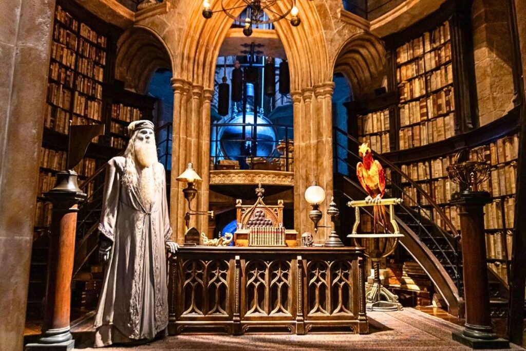 Dumbledore standing in his office next to phoenix, Fawkes.