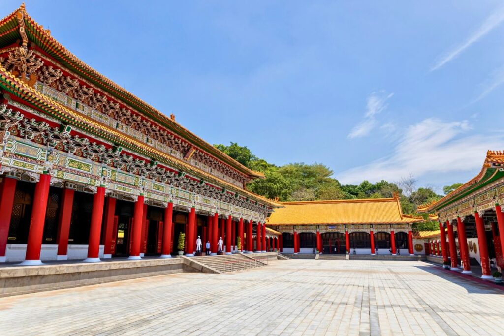 Intricately decorated buildings with gold roofs and red columns.