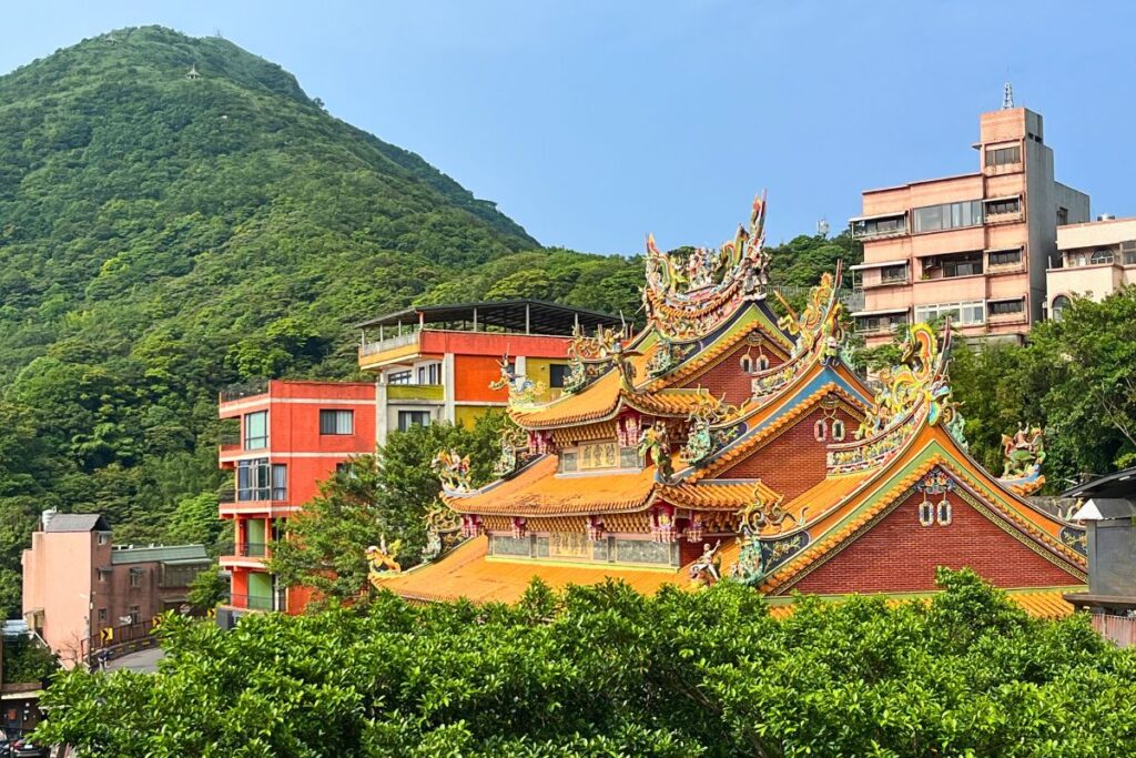 A temple in Jiufen surrounded by hills and greenery.