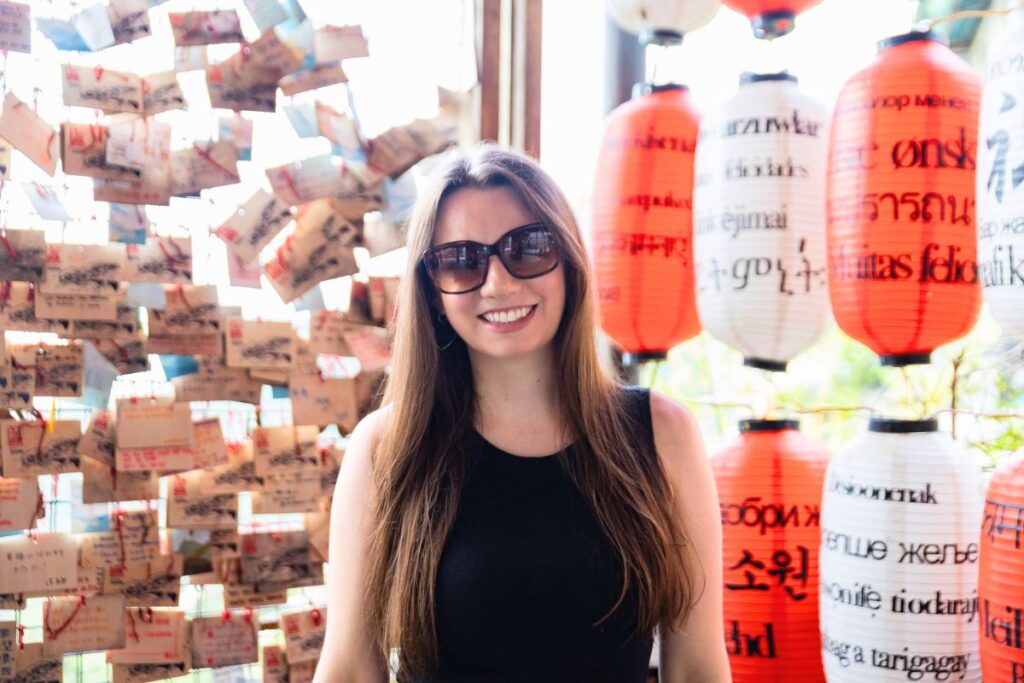 Krysti smiling in front of red and white lanterns on Jiufen Old Street.