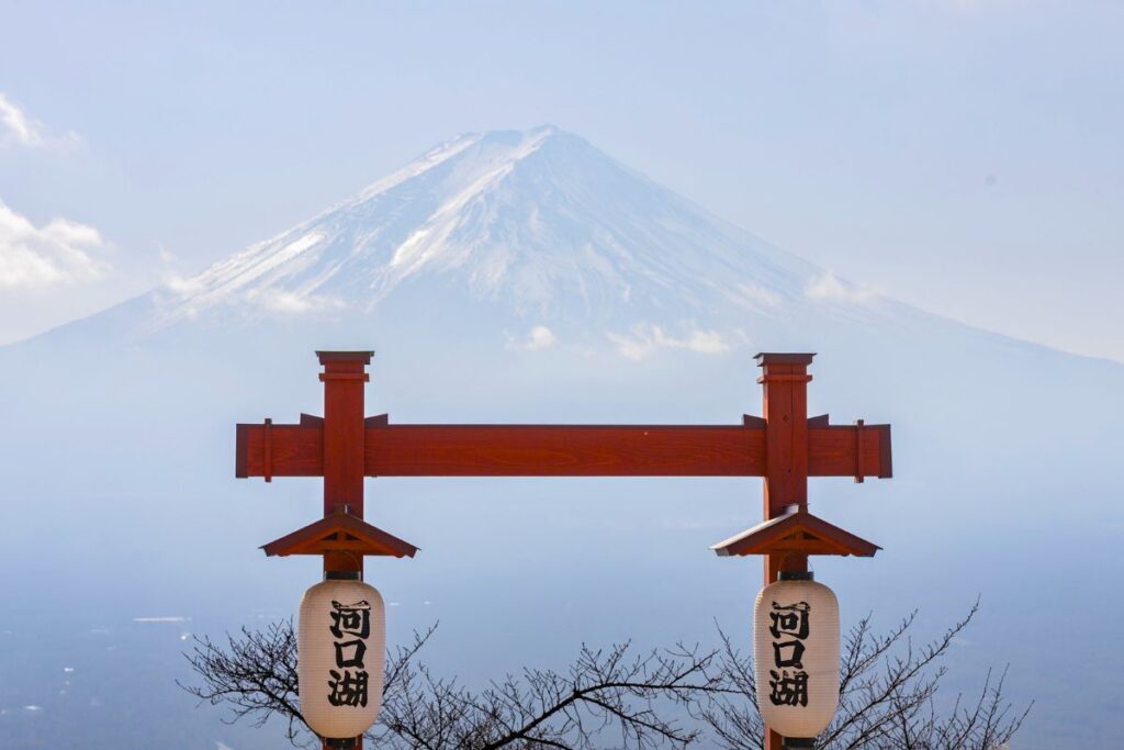 A close up shot of Mount Fuji with a red torii gate in front of it.