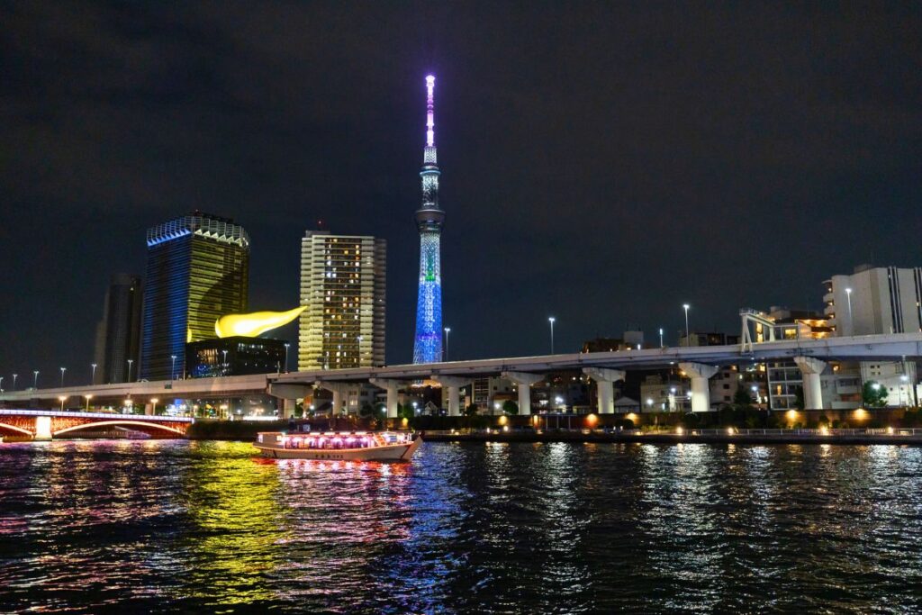 Sumida River at night with Tokyo Skytree lit up in the background.