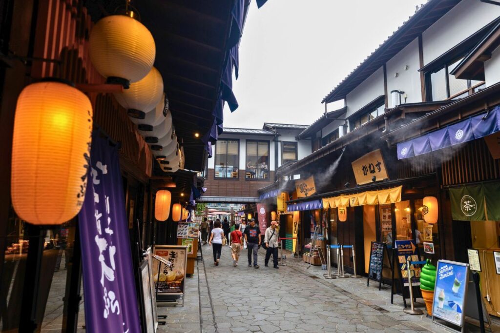 Toyosu Market Cobblestone street lined with local food vendors and traditional Japanese lanterns.
