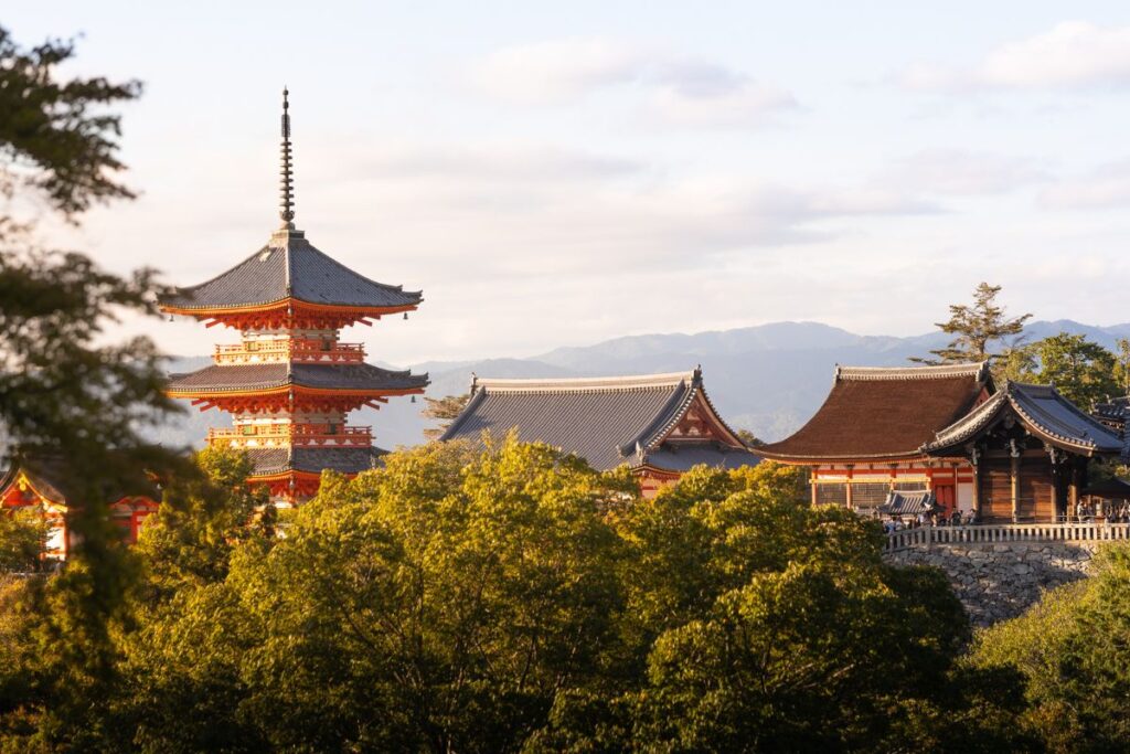 A large red pagoda and the roofs of prayer halls at Kiyomizu-dera Temple in Kyoto