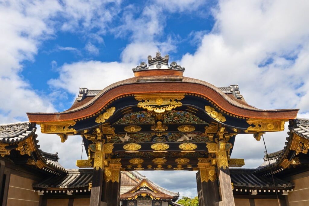 A wooden gate covered in intricate gold designs.