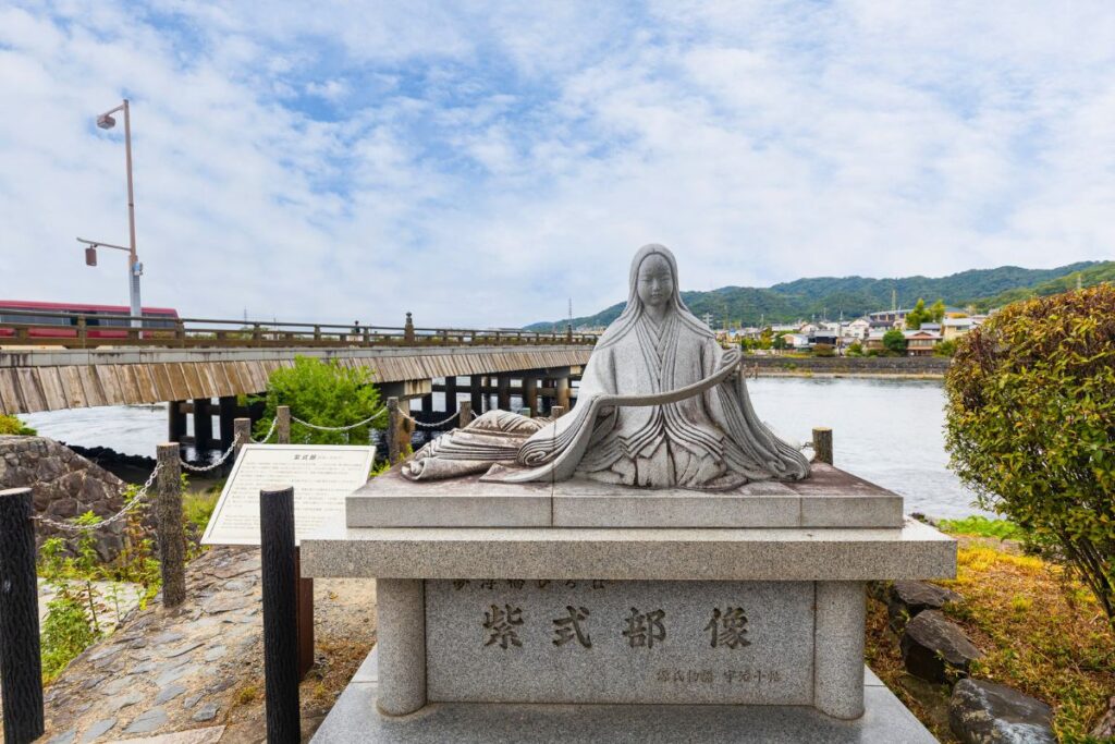 The statue of Murasaki Shikibu with Uji Bridge in the background