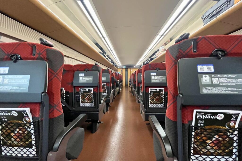 A view looking down the aisle between seats in a car on the Shinkansen