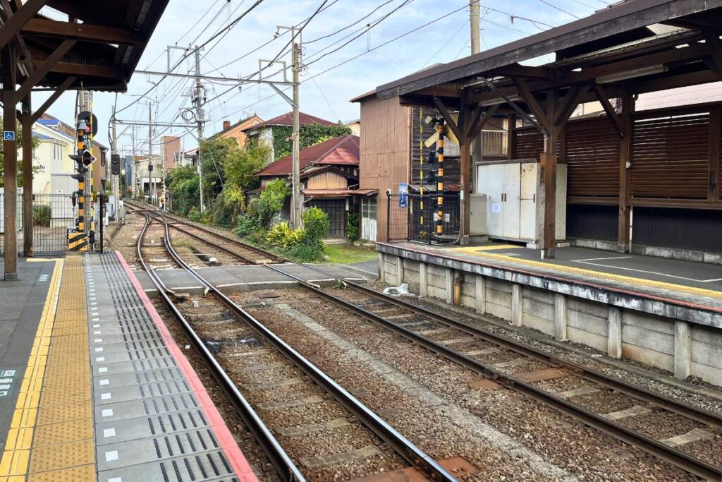 Empty train track next to a platform at a train station in Japan.