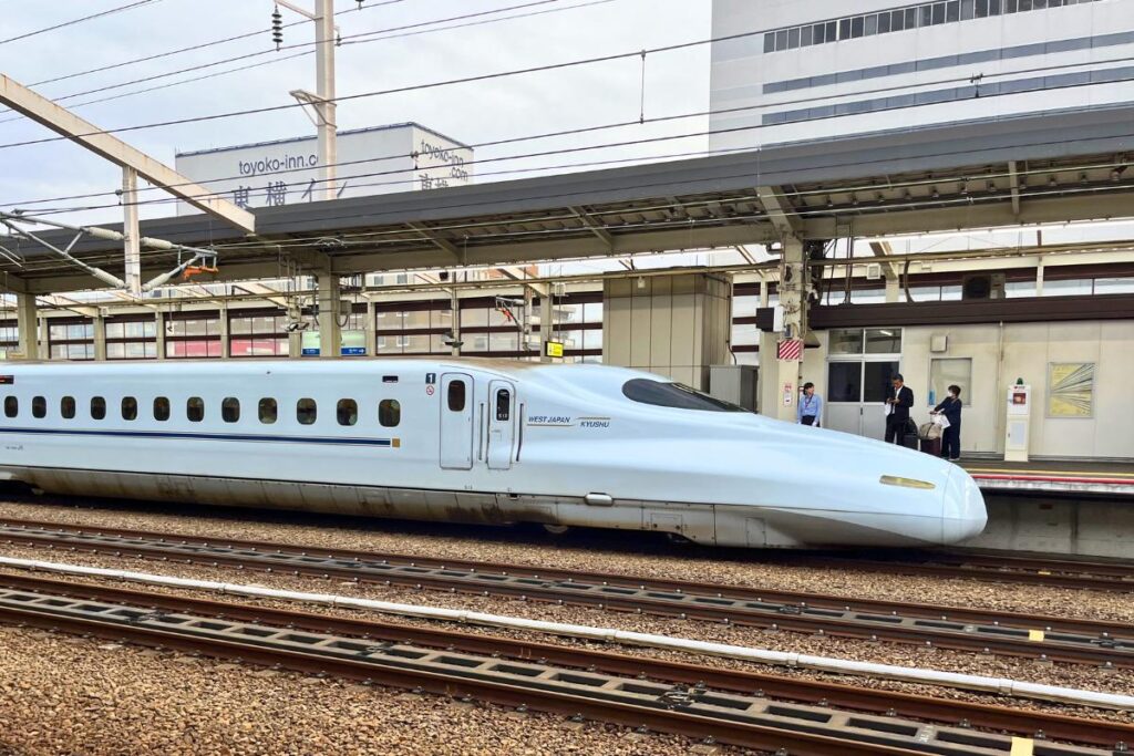 A white bullet train pulling into a station in Japan.