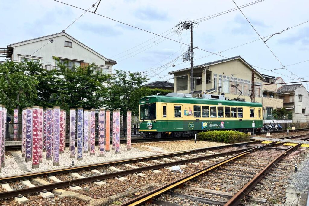 A green and yellow tram in Kyoto.