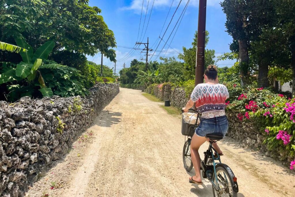 Krysti biking through the stone-lined streets of Taketomi Island.
