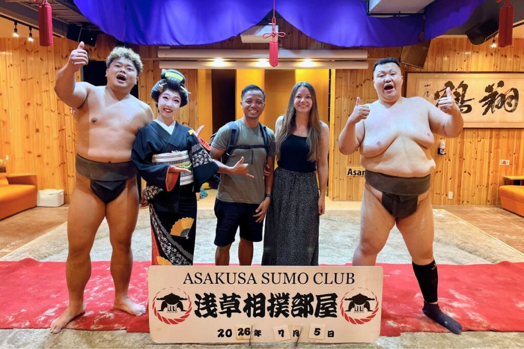 Krysti and her husband posing with sumo wrestlers and a geisha at the Asakusa Sumo Club.