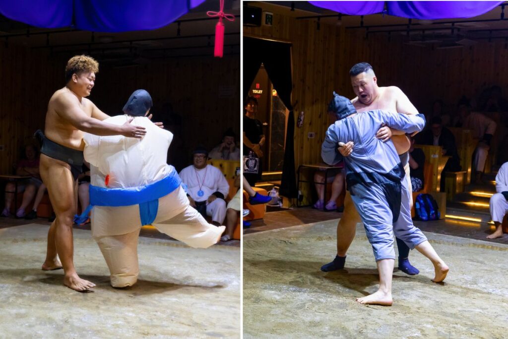 Professional sumo wrestlers playfully fighting audience members at the Asakusa Sumo Club.
