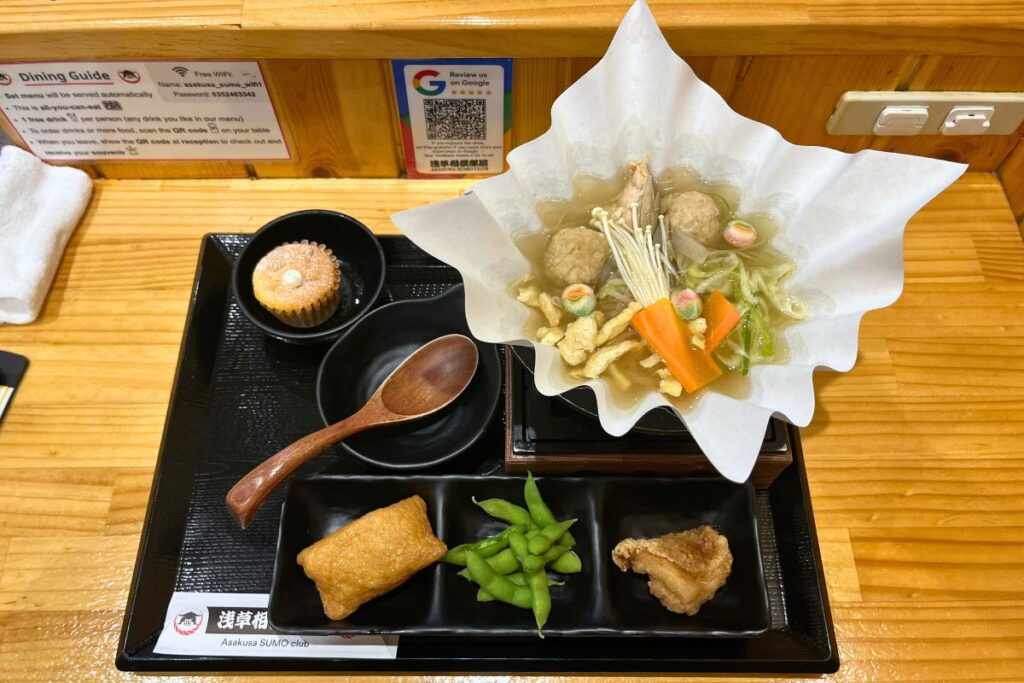 A tray with hot pot soup and several sides.