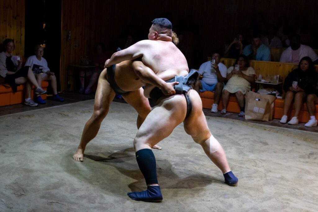 Two sumo wrestlers going head to head at the Asakusa Sumo Club.